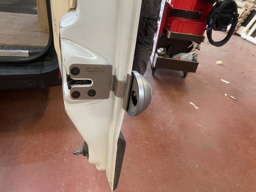 Verrou antivol CARGOBLOCK posé sur le montant de porte d'un fourgon, en atelier